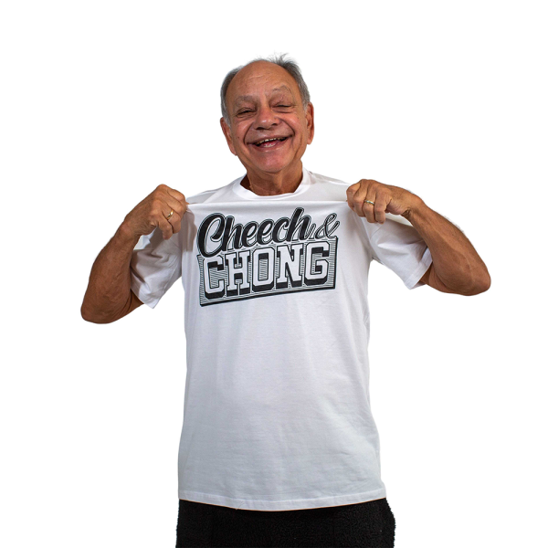 Cheech smiles. He is wearing a white shirt with black font that reads Cheech and Chong.