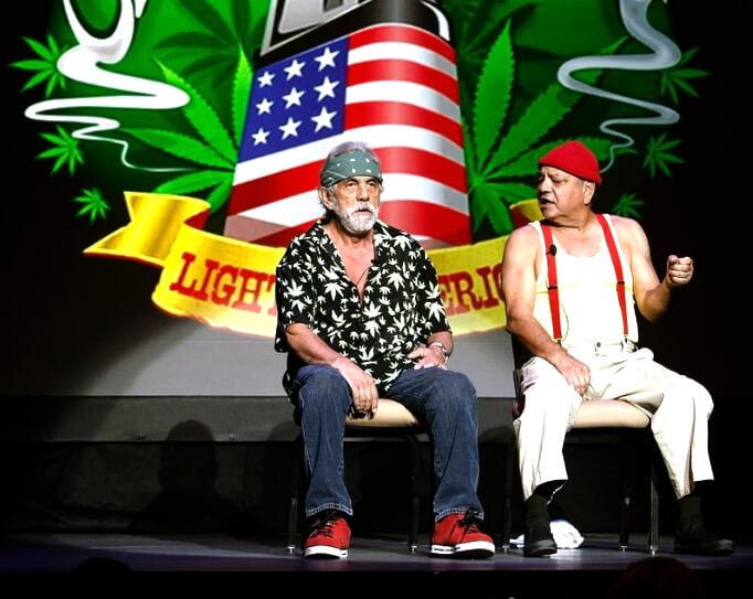 Cheech and Chong sitting and preforming on stage together.